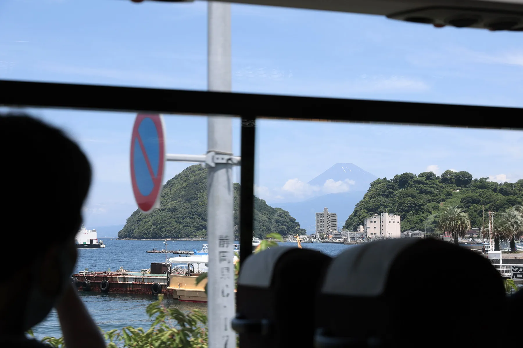 バスの車窓越しに青々とした淡島と富士山が見えている