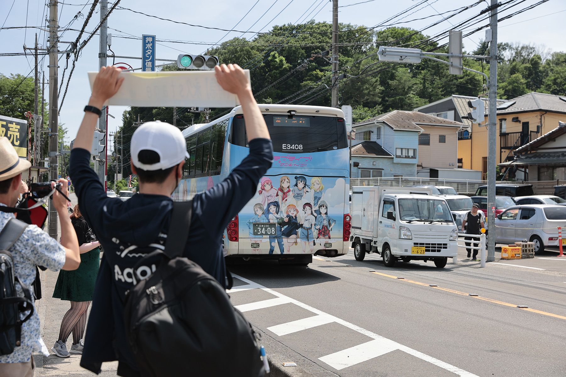 バスを見送っている自分 うれしそう ボードを掲げ、バスを見送る自分