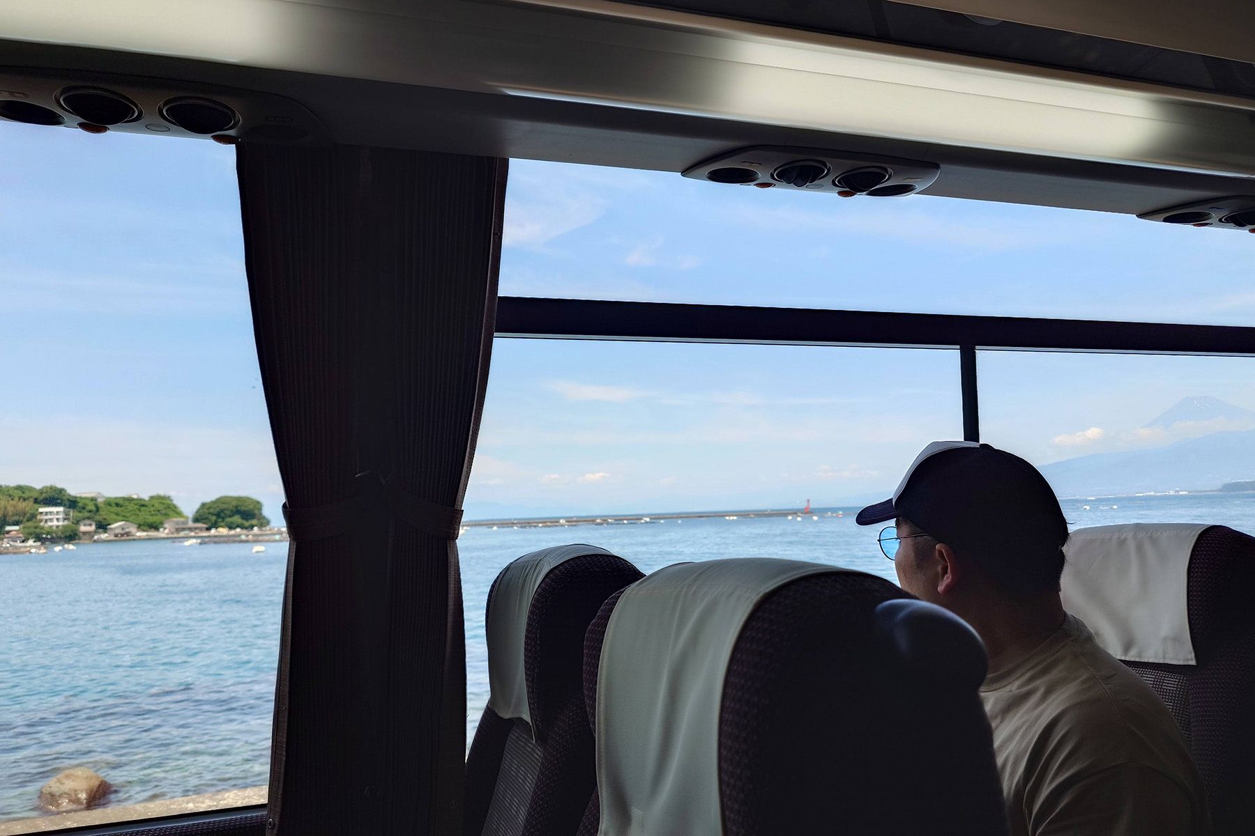 この日はいつにも増して本当に海がきれいだった バスの車窓越しの海とそれを眺める人物